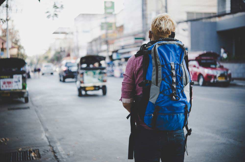 Traveler with a backpack standing at a train station in a foreign city, checking a map
