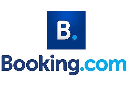 Booking.com homepage on a laptop screen showing hotel listings, prices, and search filters for travel accommodation"