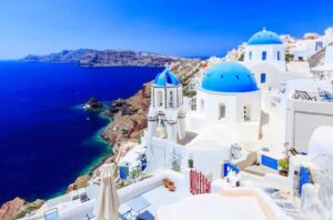 Whitewashed buildings with blue domes overlooking the Aegean Sea in Oia, Santorin